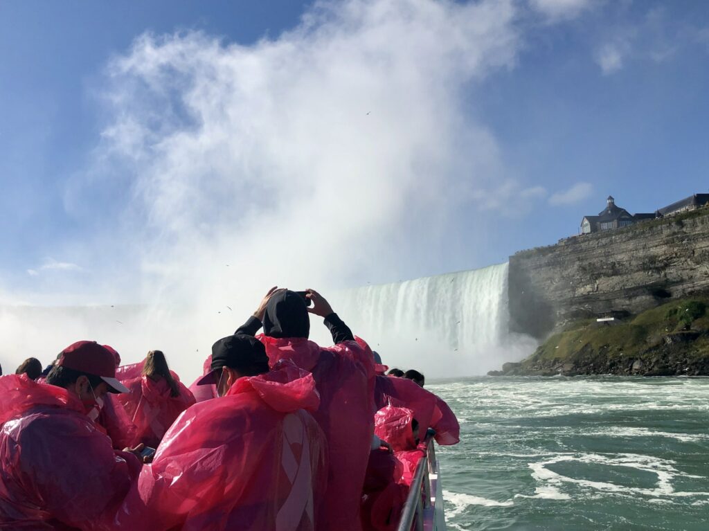 Tourists on maid of the mist taking photos of Niagara Falls