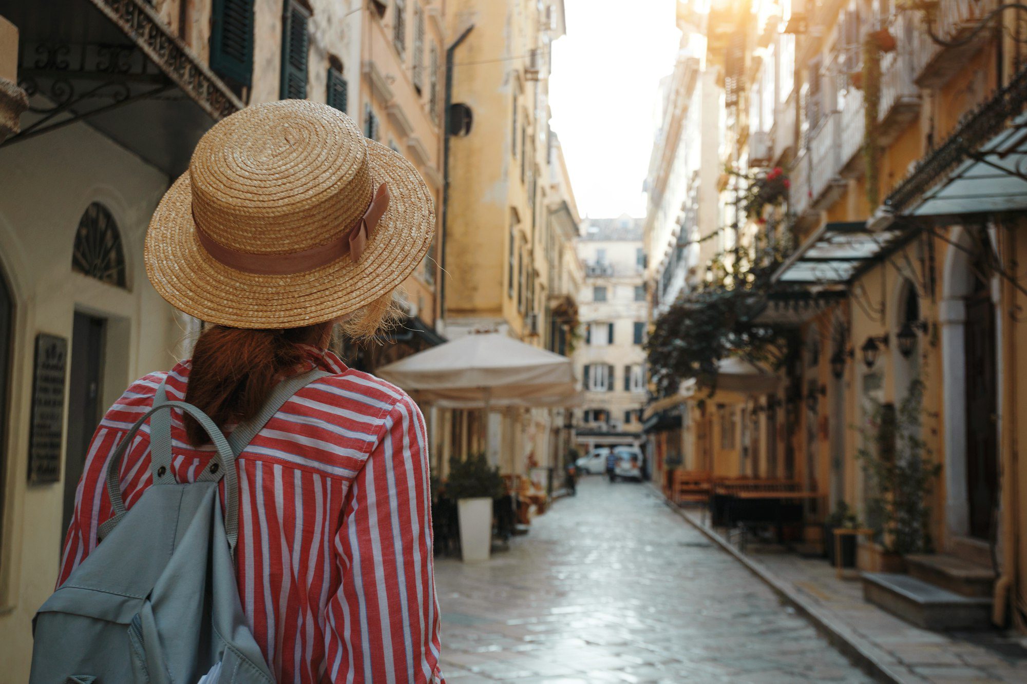 girl in a hat walks on the street of the ancient Greek city